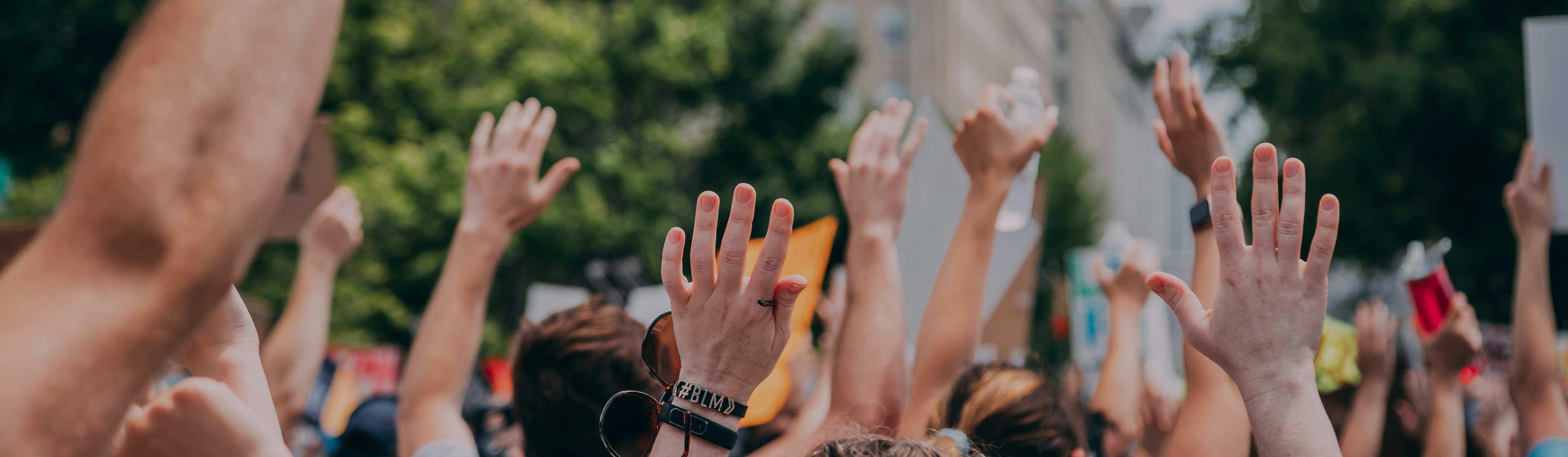 Young people raising their hands together at a rally